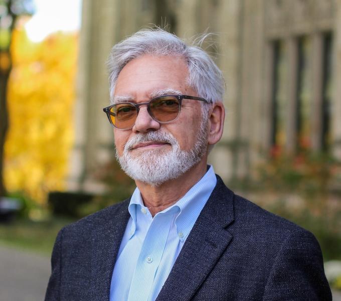 Michael F. Pogue-Geile headshot in front of the Cathedral of Learning